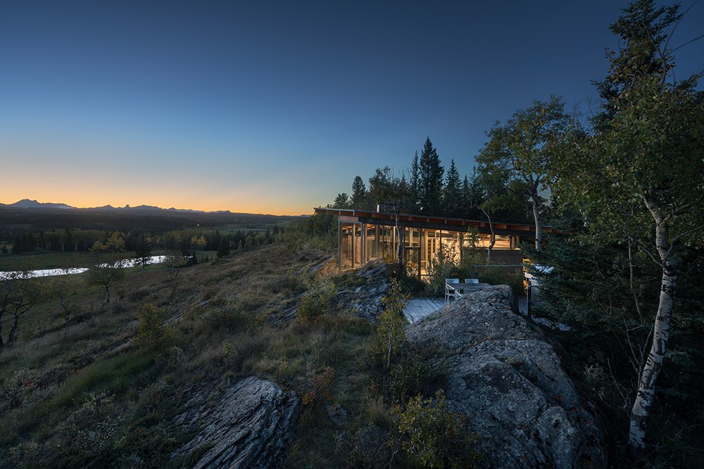 Rock House at dusk, with the sun casting a warm glow behind the Rocky Mountains